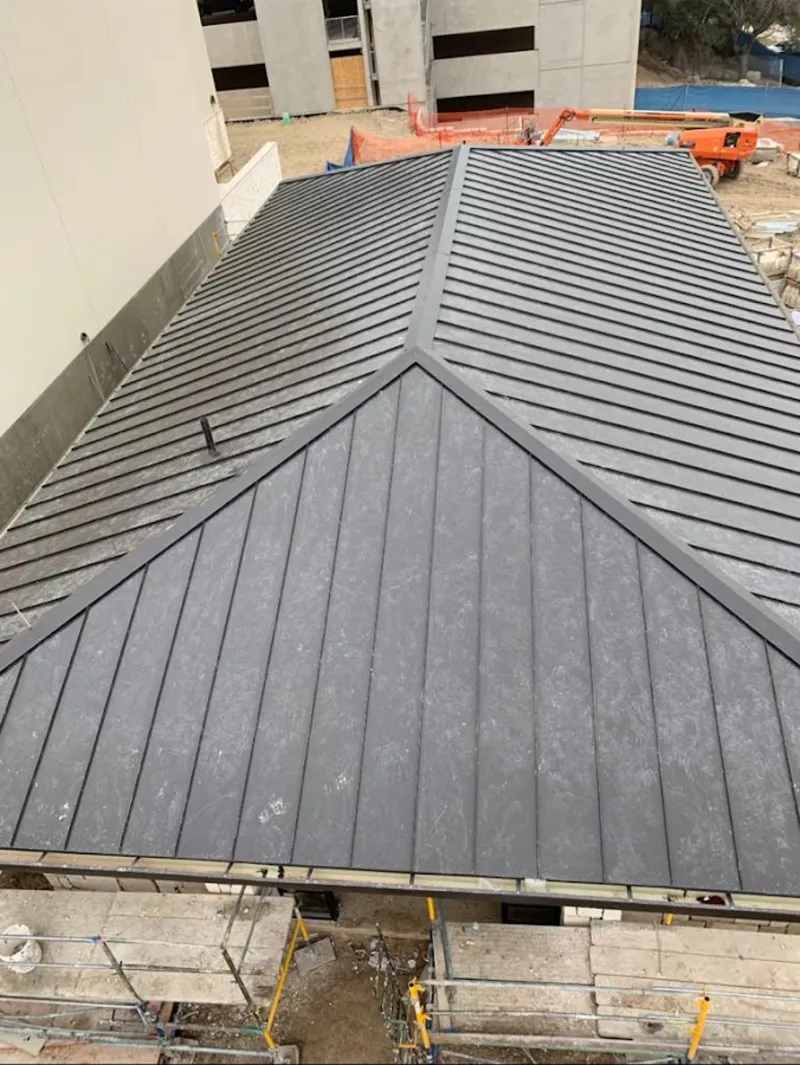 Commercial metal roof construction with crane equipment in Iroquois Point